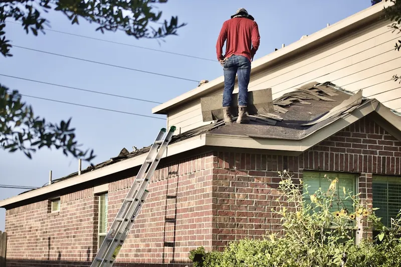 Professional roofer working on a residential roof in Wampsville